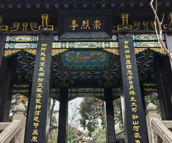 Tianxin Pavilion Historic Area,Changsha,Chinatravel Ornate Chinese temple gate with gold inscriptions, black pillars, and a tiled roof leading to a courtyard with visitors.