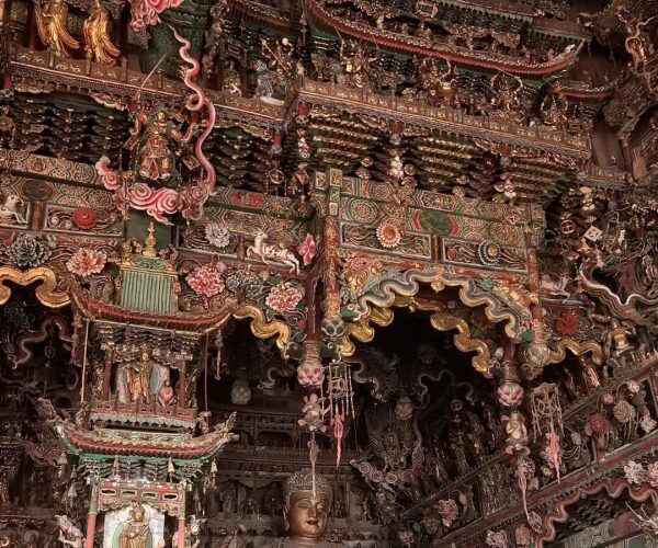 Xiaoxitian (Hanging Temple),Linfen,Chinatravel Intricately carved Asian temple interior with Buddha statues and colorful dragon motifs.