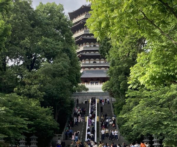 Leifeng Pagoda,Hangzhou,Chinatravel Crowded stone staircase leads up to a traditional multi-story pagoda surrounded by green trees.