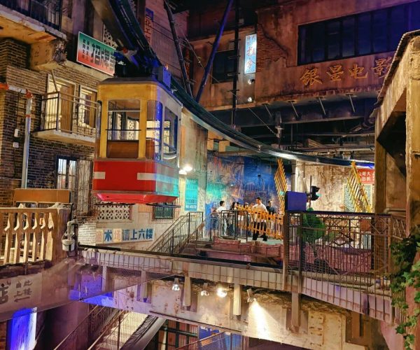 Huangxing Road Pedestrian Street,Changsha,Chinatravel Night scene of a historic alley with an orange suspended tram car and overhead cables, pedestrians on a walkable platform amid brick buildings and neon signs at night.