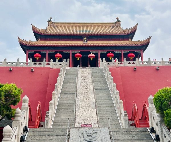 Dragon Pavilion Park,Kaifeng,Chinatravel Temple with red walls and ornate curved roofs, stairs leading to a pagoda-style hall adorned with red lanterns.