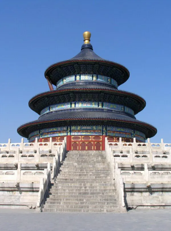 Temple of Heaven, Beijing, Chinatrip, Circular, multi-tiered Chinese temple with blue-green ceramic tiles and gold accents, perched on a stone stairway with a white railing under a clear blue sky.