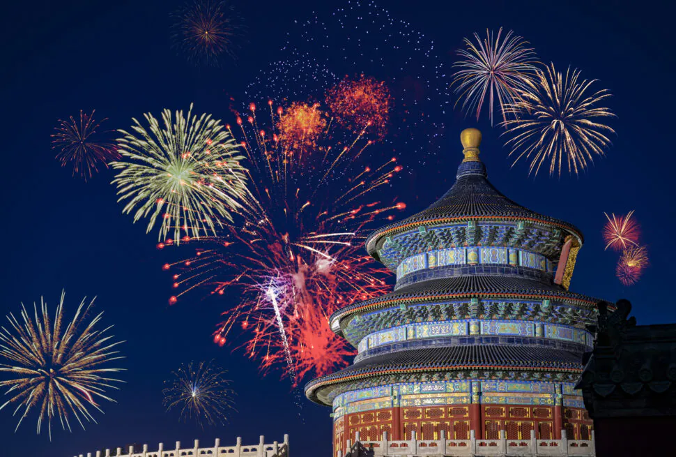 Fireworks light the night sky over the Temple of Heaven in Beijing, highlighting the circular ornate roof.