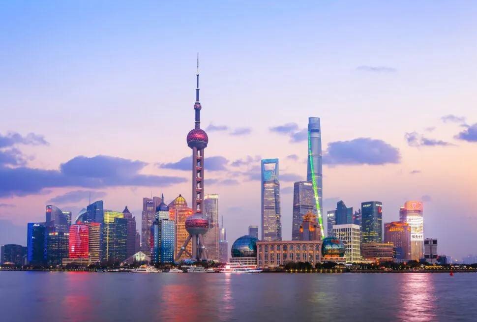 A Guide to Chinese Accommodation: Hotels, Hostels, and More, chinaexplorertour, Evening view of Shanghai skyline along the river with the Oriental Pearl Tower and illuminated skyscrapers.