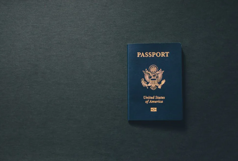 China Travel Guide 2025: Visa, Transportation, Itineraries and More, chinaexplorertour, Blue US passport with gold seal on a dark textured background.