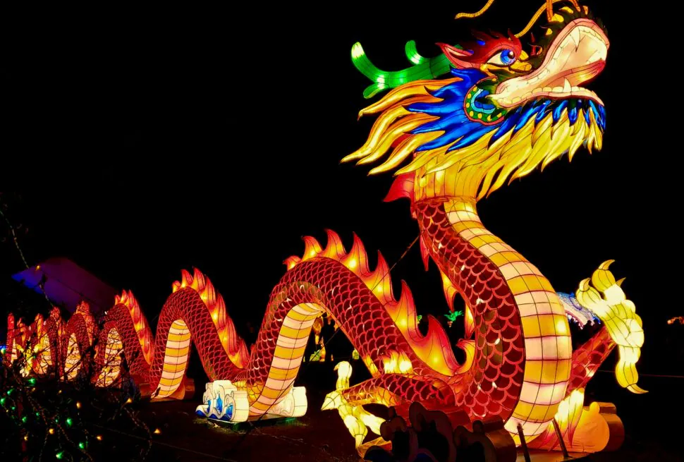 Discover the Magic of Chinese New Year 2025, chinaexplorertour, Colorful illuminated dragon lantern with a long serpentine body and bright mane at night.