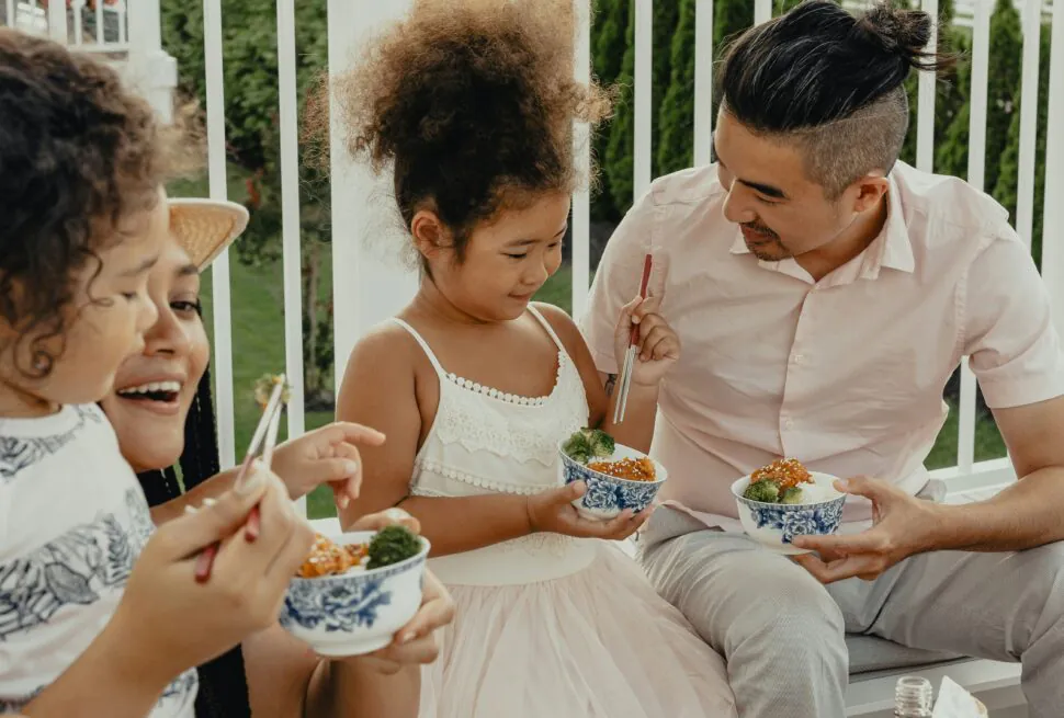 China Culture: Do’s and Don’ts for your China Trip, china, chinaexplorertour, A family sharing a meal on a balcony: two young girls and a man with a girl in a white dress enjoy bowls of food together.