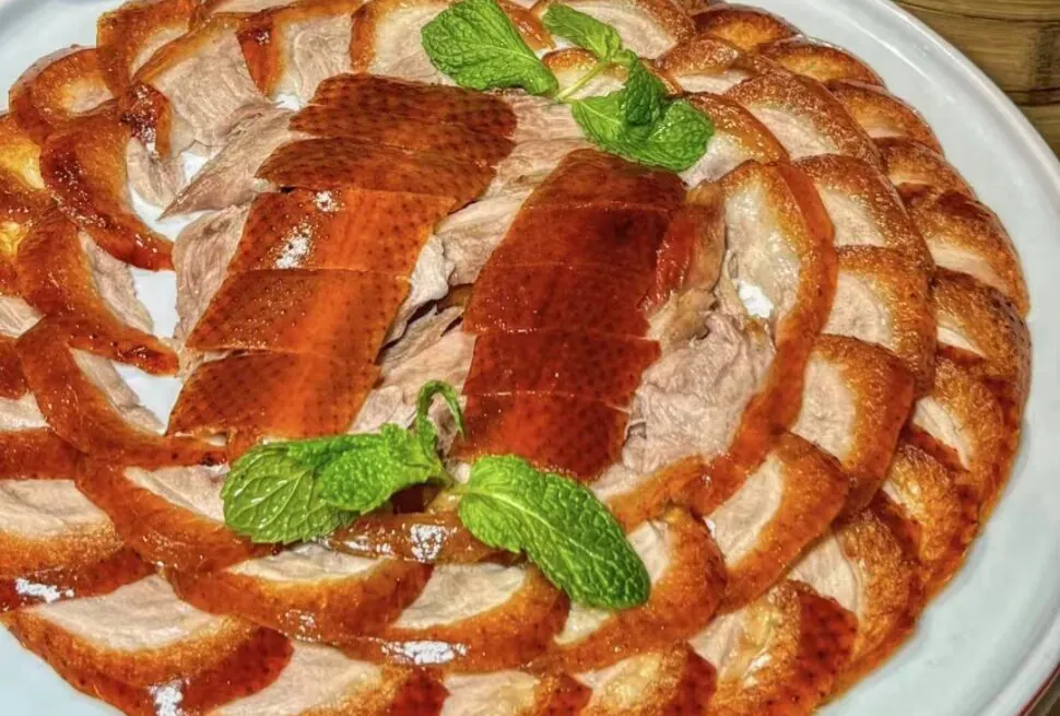 Peking Roated Duck with thin pancakes, scallions, cucumber strips, chinese cuisine, china, china tour, Sliced roasted turkey arranged in a circular rose pattern on a white platter, garnished with mint leaves.