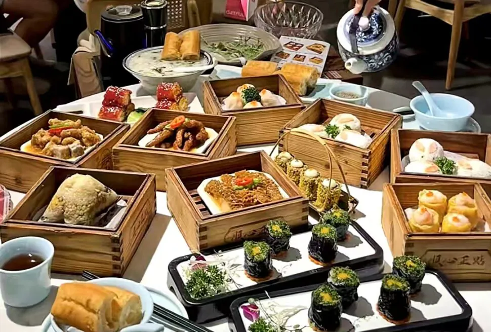 Cantonese Morning Tea, chinese cuisine, china, china tour, Assorted dumplings, sushi, and dim sum in wooden steamers on a dining table.