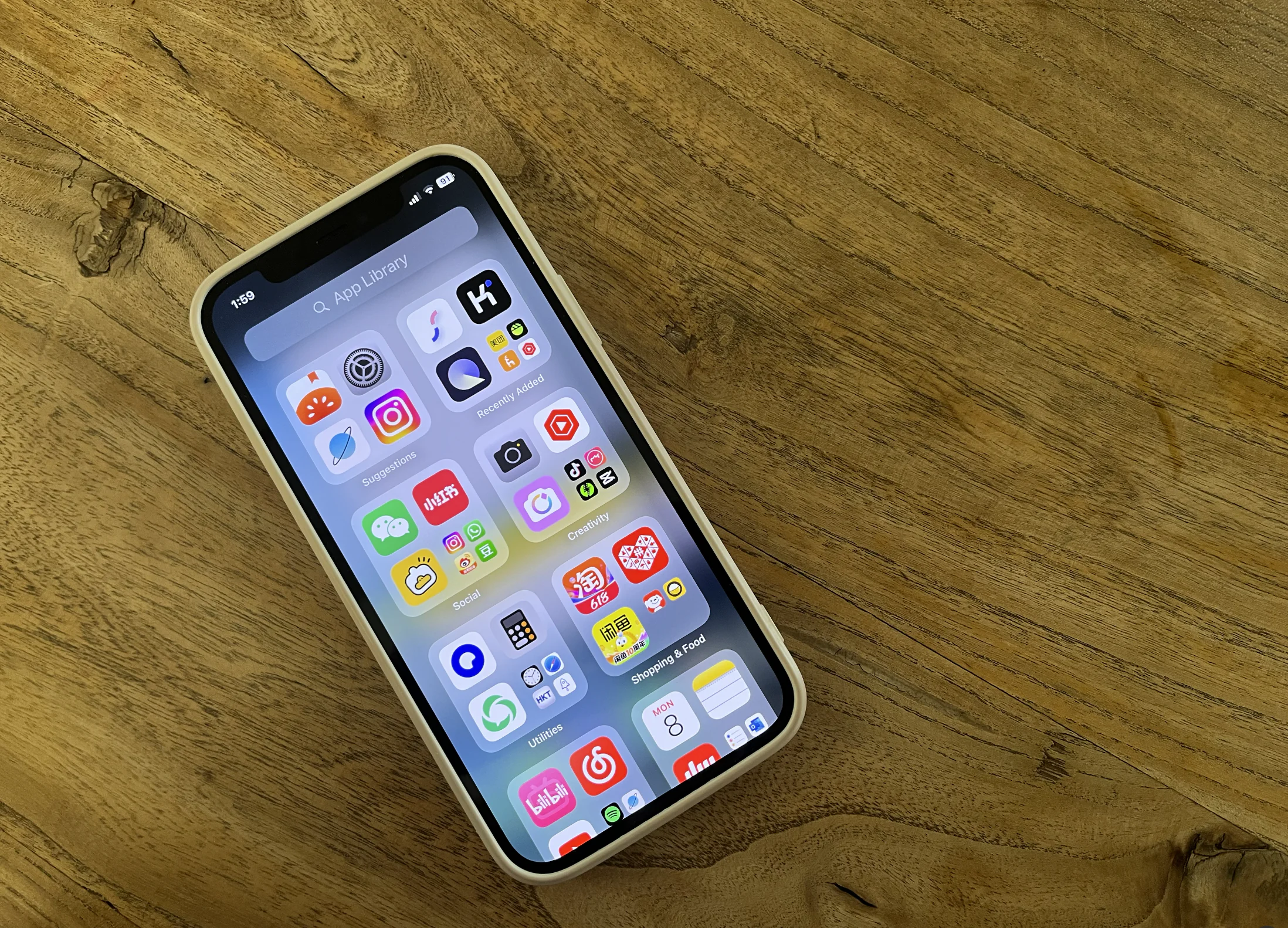 How To Stay Connected In China 2025: Internet, VPN And SIM Cards, chinaexplorertour, Smartphone with a grid of colorful app icons on a wooden table surface, seen at an angle.