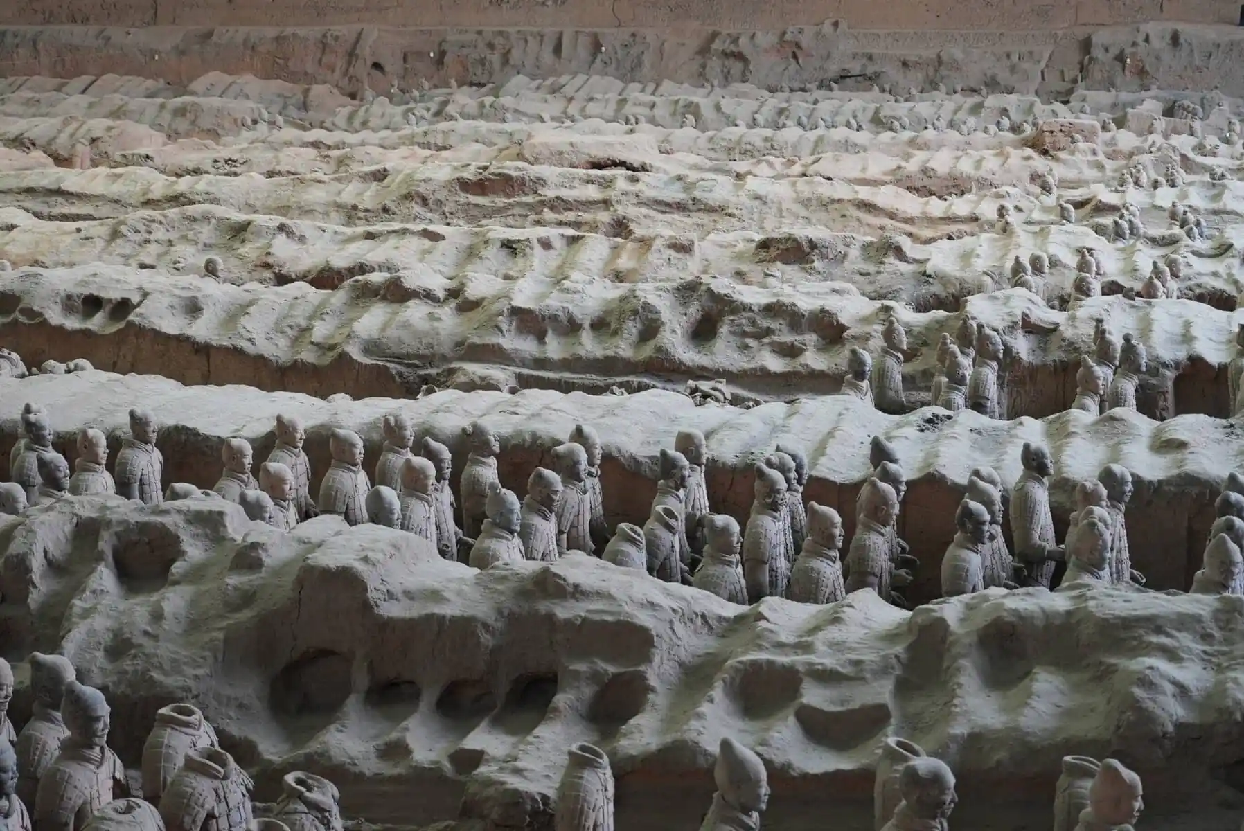 Terra Cotta Warriors, xi'an, china, china tour, Row upon row of life-size terracotta soldiers standing in an ancient excavated pit, part of the Terracotta Army display.