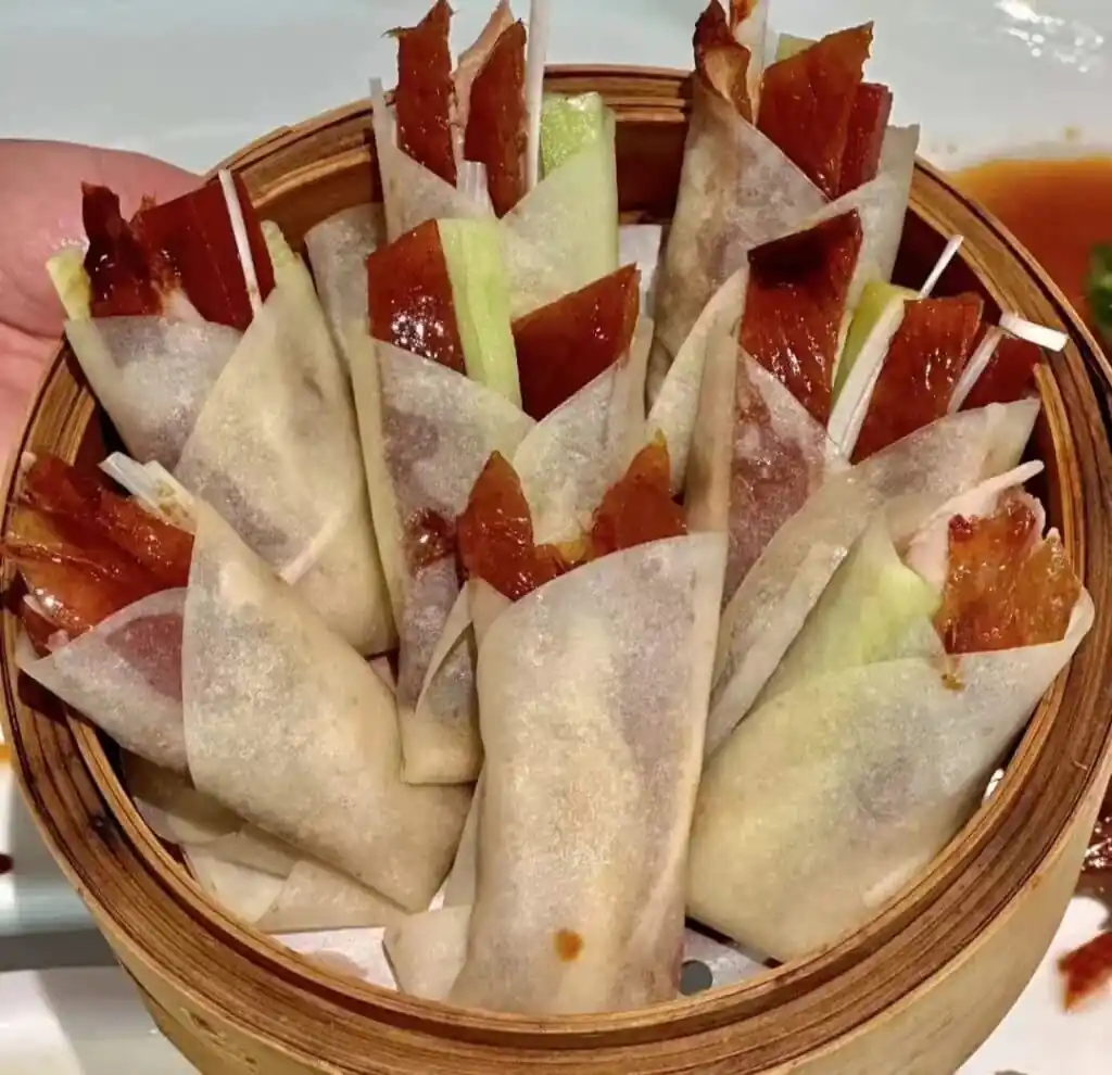 beijing duck, china tour, Basket of translucent spring rolls filled with char siu pork and vegetables, arranged upright in a wooden steamer basket.