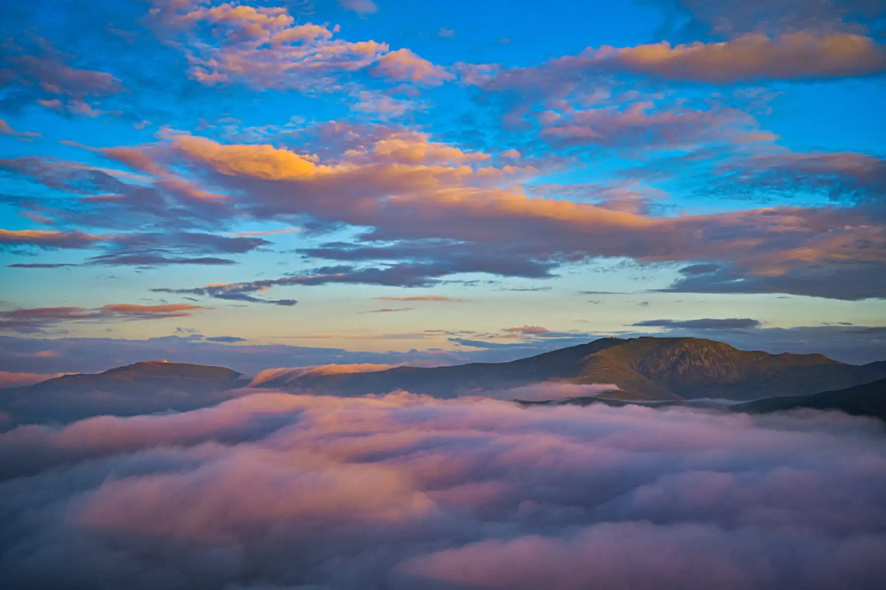 Mount Wutai, shanxi, china, china tour, Mountains rise above a sea of pink clouds under a blue-orange sunset sky, creating a tranquil alpine scene.