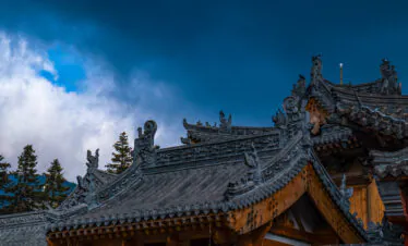 Mount Wutai, shanxi, china, china tour, Ornate Asian temple roof with carved dragons and decorative tiles, blue sky in background.