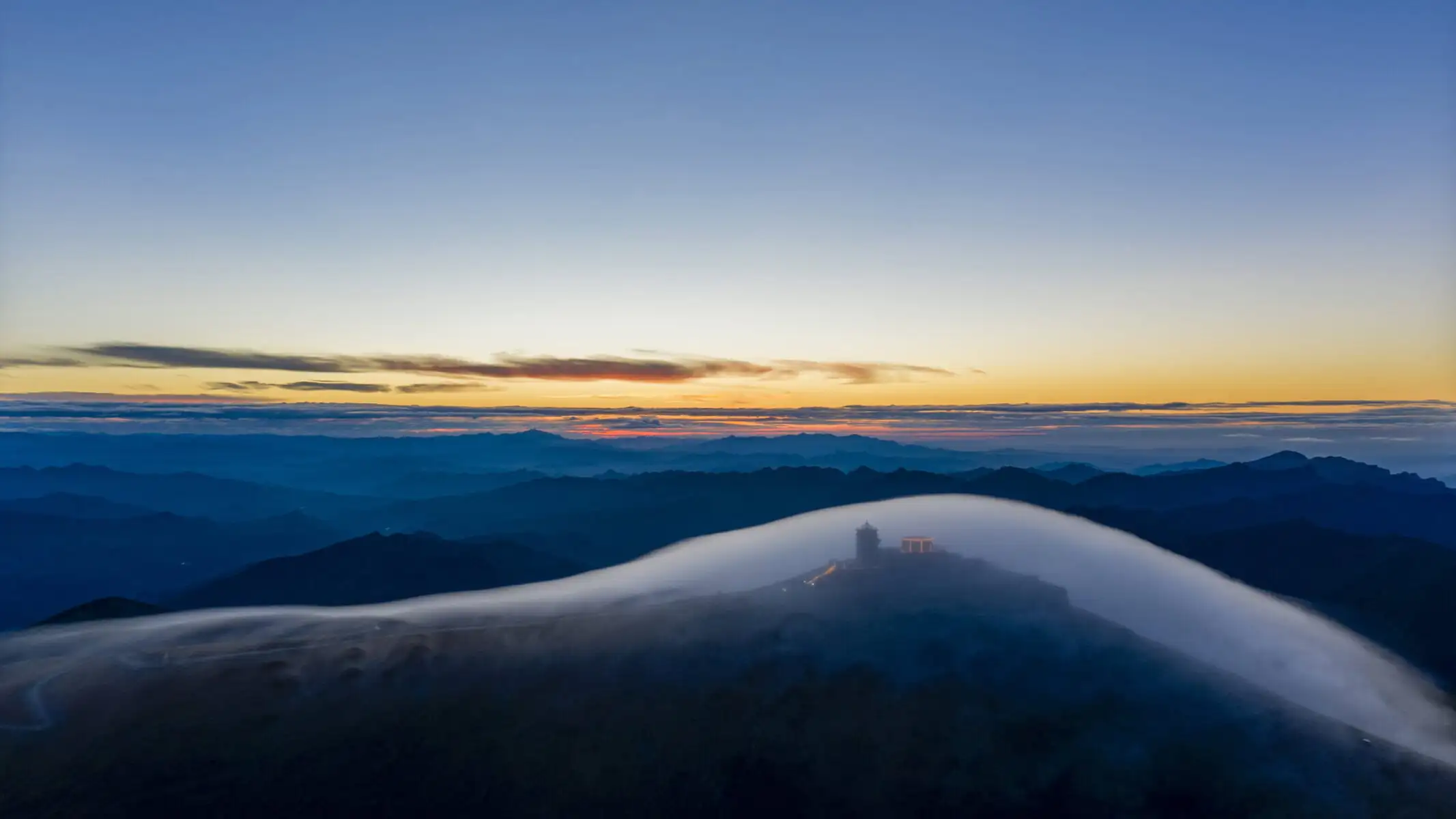 Mount Wutai, shanxi, china, china tour, Sunset over a layered mountain range with blue silhouettes and a pale mist rolling through the valley.
