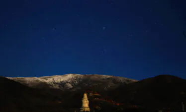 Mount Wutai, shanxi, china, china tour, Night sky filled with stars over snow-dusted mountains and a lit Buddhist stupa in the foreground