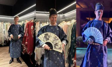 Hanfu Photoshoot, chinese traditonal dress-up, song dynasty, beijing, male, solo, china tour, Man in blue traditional robe posing among racks of garments in a store, holding a hat in front.