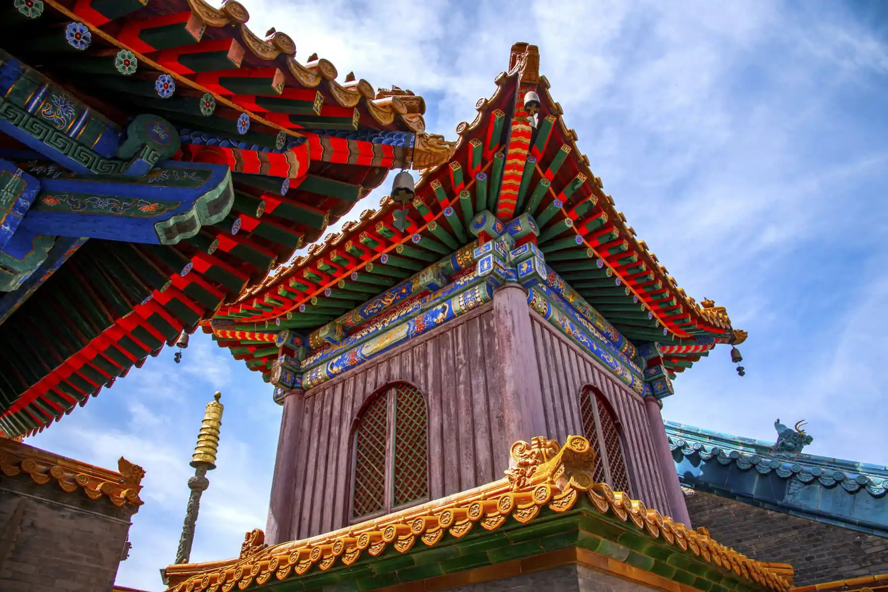 Architectural Details of Pusading, Mount Wutai, shanxi, china, china tour, Colorful Chinese temple roof with ornate eaves and decorative motifs against a blue sky