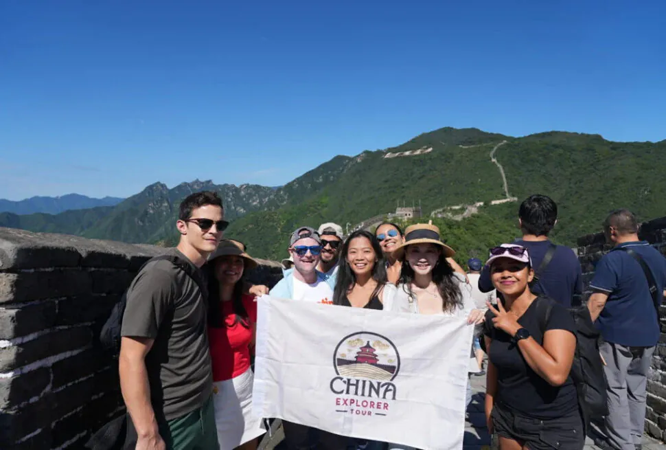 the Great Wall, beijing, cet team, chinaexplorertour, Group of travelers posing on the Great Wall of China, holding a banner that reads China Explorer Tour.