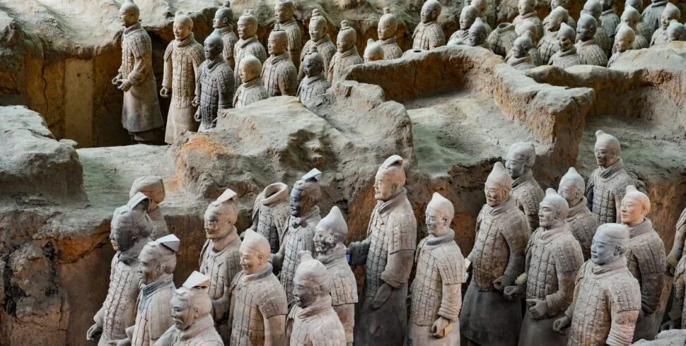 Terracotta Army museum. Xi'an. Chintravel, Rows of life-sized terracotta soldiers standing in excavated earthen pits, part of China’s Qin dynasty mausoleum.