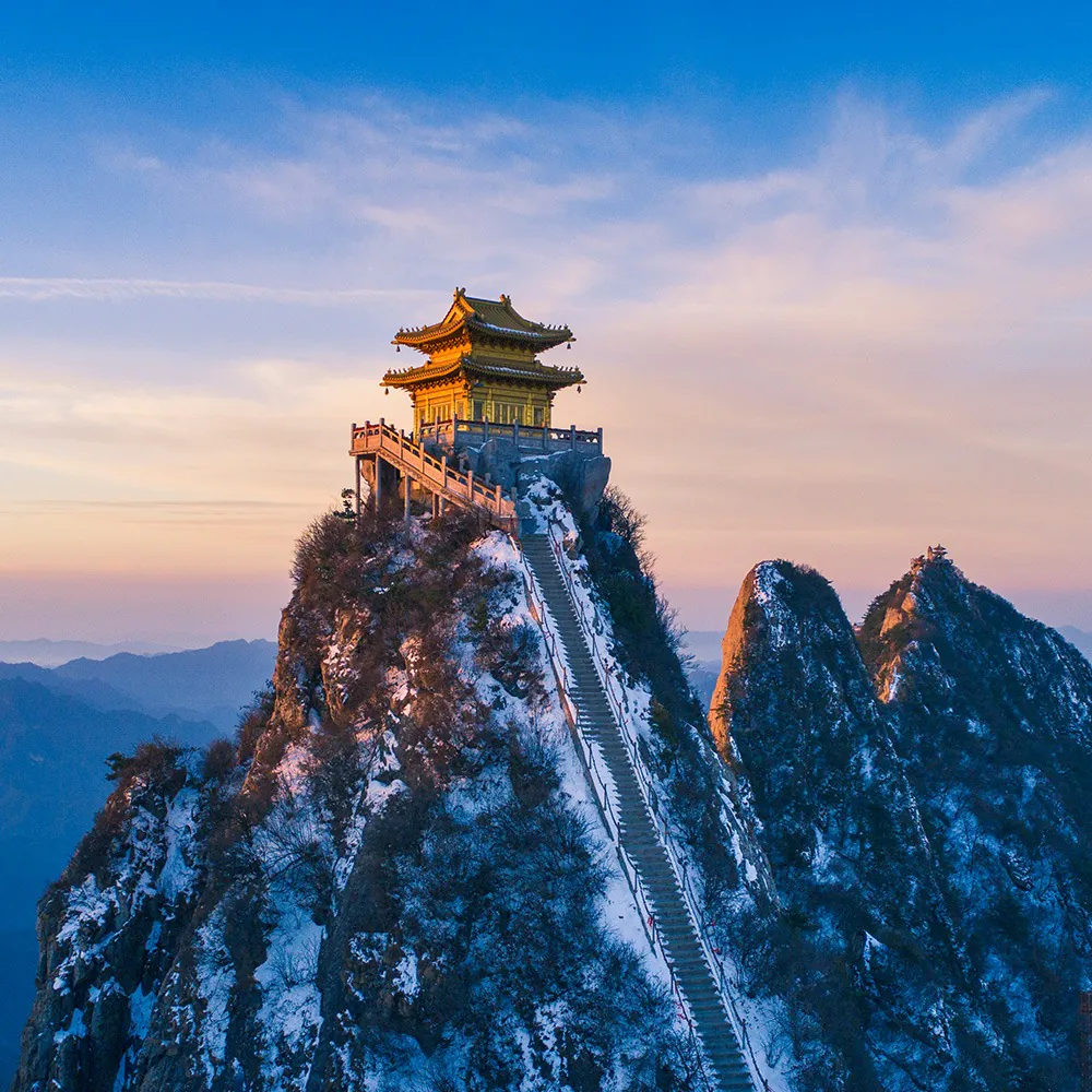 Laojun mountain, luoyang, henan, china tour, Temple atop a snow-covered peak with a long staircase leading to it at sunset/blue hour, mountains in the distance