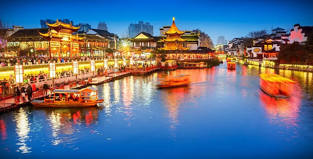 Fu Zi Temple, nanjing, jiangsu, china tour, Night canal scene in a traditional Chinese town with illuminated pavilions and boats on the water along a lit promenade.