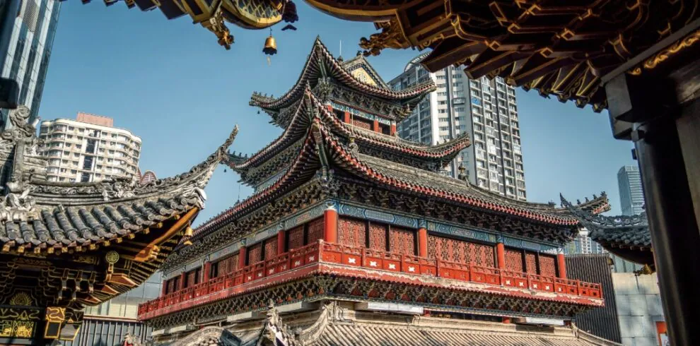 Luohan Temple, Arhat Temple, chongqing, chinatrip, Red multi-tiered Chinese temple with ornate upturned eaves framed by modern high-rise buildings in a cityscape