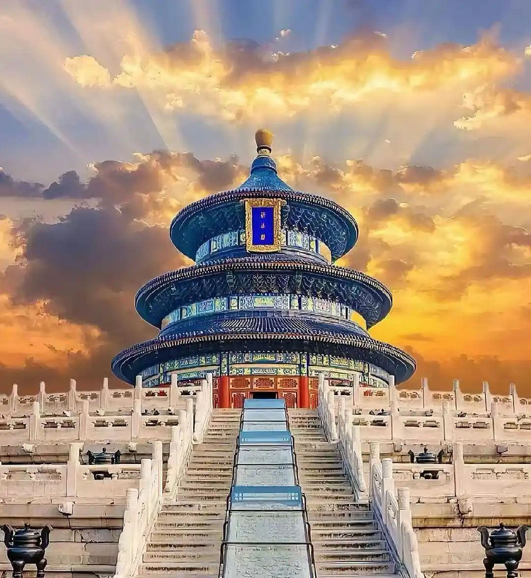 Circular blue-tiled pagoda (Temple of Heaven) atop steps leading to the shrine, with a golden sunset sky behind us.
