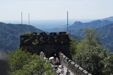 The Great Wall,Beijing,Chinatour Section of the Great Wall winding through green mountains with visitors walking along the crenellated walkway