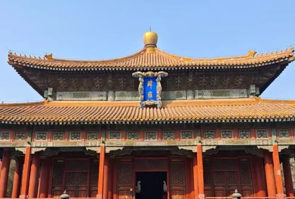 Confucius Temple and Imperial College,Beijing,Chinatour Front view of a traditional Chinese temple with orange tiled roof, red columns, and carved wooden doors against a clear blue sky.