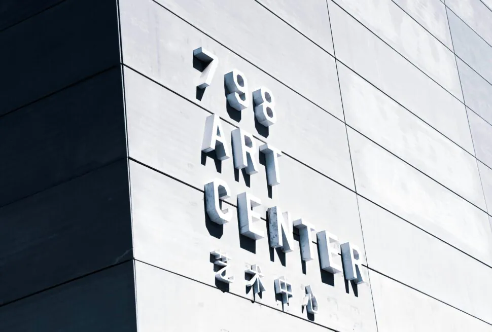 Exterior view of a modern building facade with large 3D letters reading '798 ART CENTER' on light panels