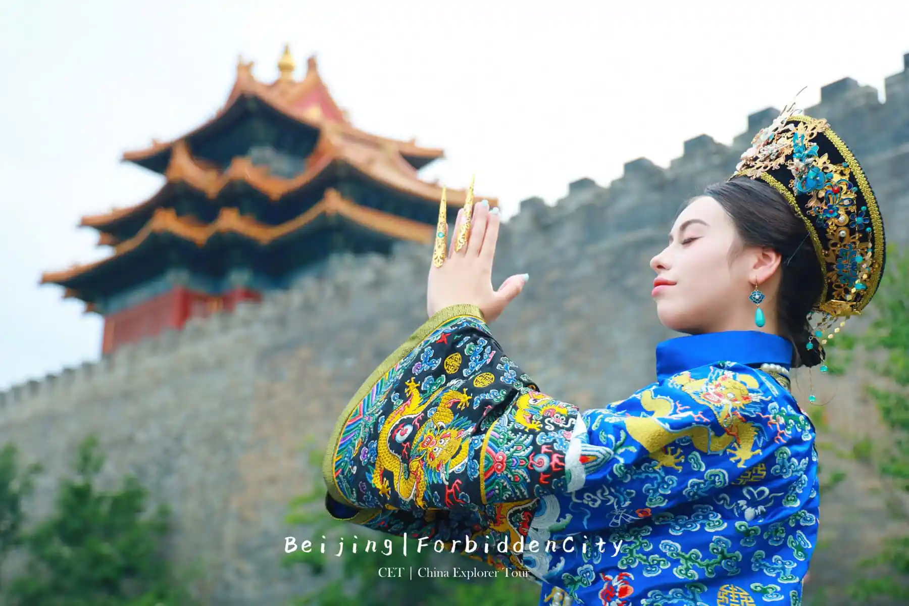 hanfu photoshoot, the forbidden city, beijing, qing dynasty, female, solo, chinatravel, Woman in a blue traditional Chinese costume with an ornate gold headdress, hands raised in a prayer gesture, with a temple wall behind.