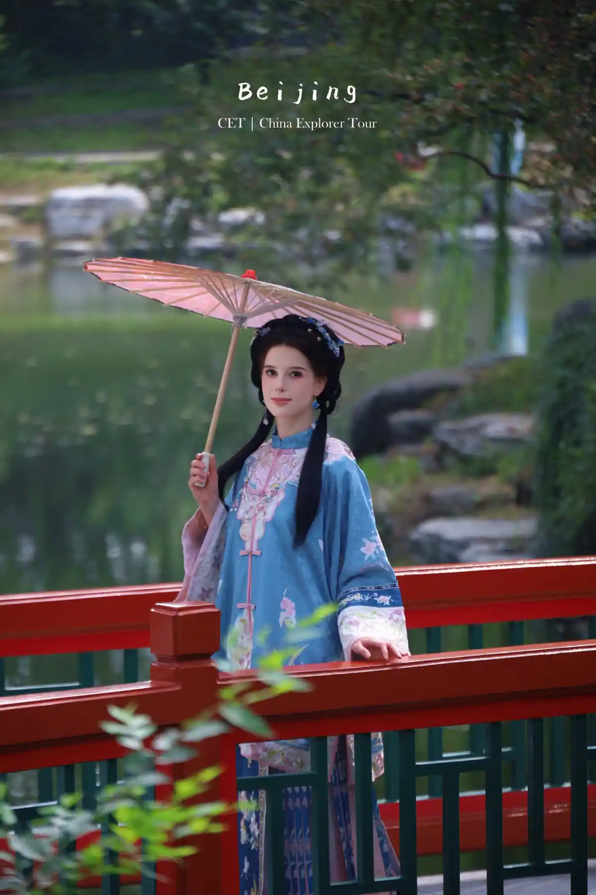 hanfu photoshoot, the forbidden city, beijing, qing dynasty, female, solo, chinatravel, Woman in a blue traditional Chinese dress holding a pink parasol on a red railing beside a tranquil pond in a Chinese garden they likely beijing tourism context