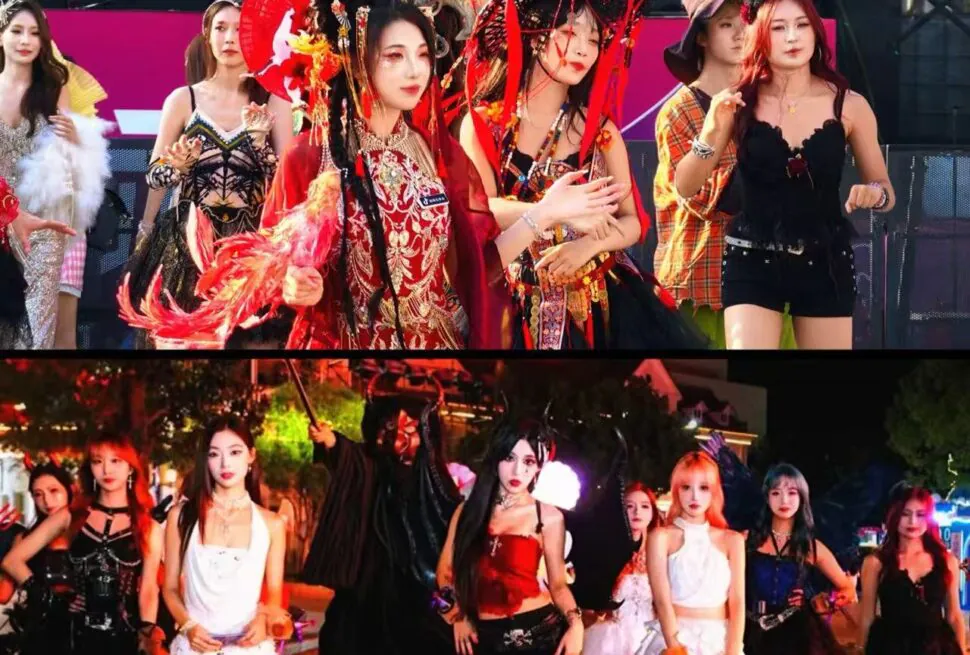 Group of women in colorful costumes posing on a stage at a night festival event.