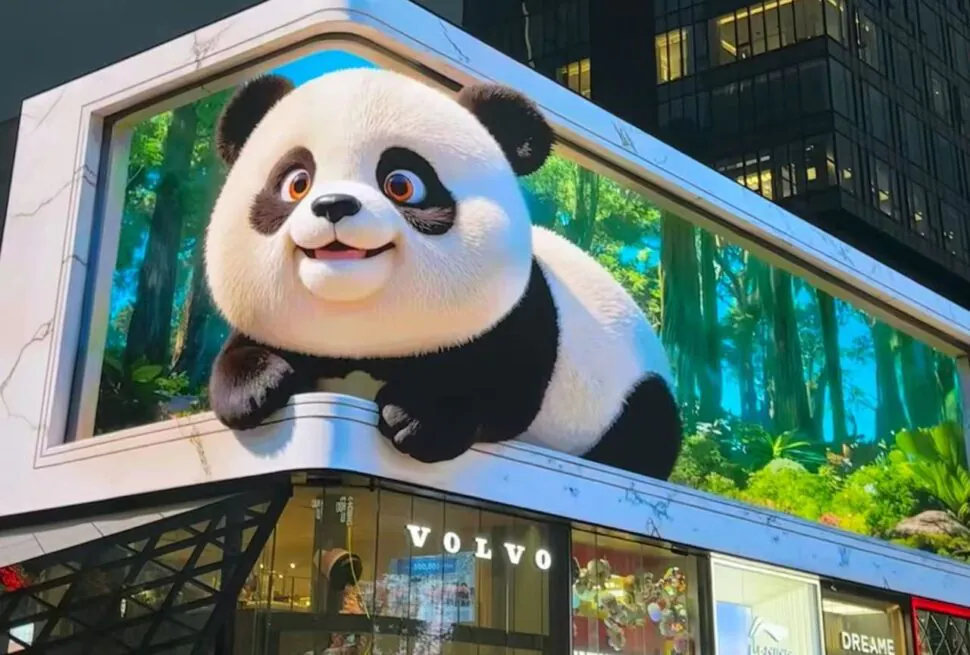 Giant panda mascot perched on a building billboard above a Volvo storefront in a city setting.