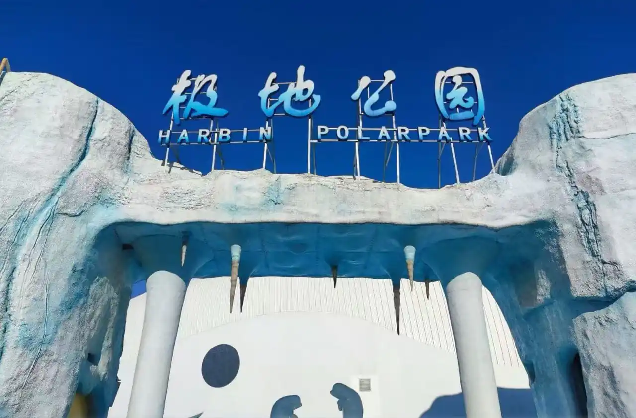 Harbin Polarland,Harbin,Chinatour Entrance to Harbin Polar Park with an icy blue arch and a blue sign reading 'Harbin Polar Park' against a clear sky.