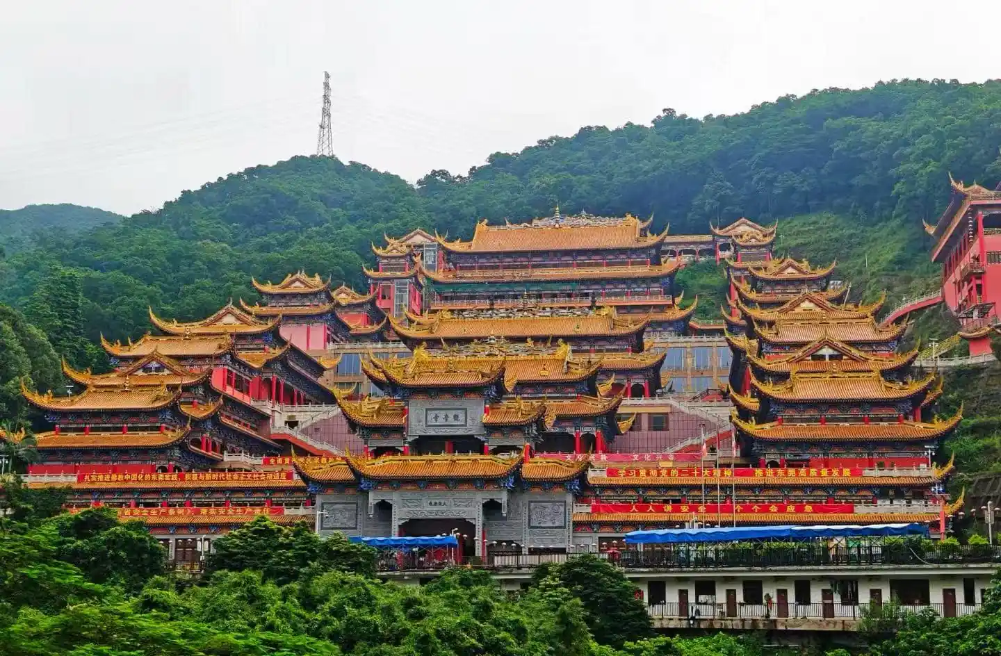 Dalingshan,Dongguan,Chinatour Multi-tiered Chinese temple complex with golden roofs perched on a green hillside atop the hill.