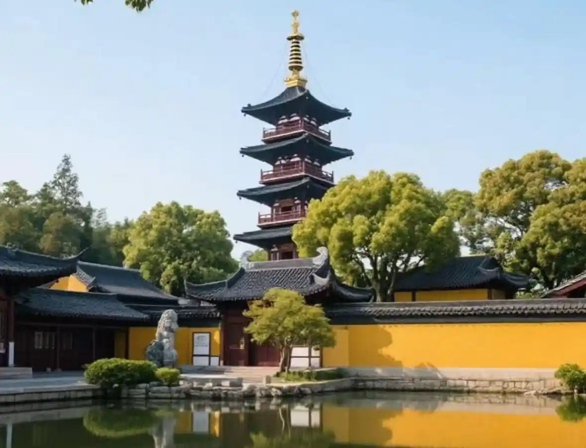 Hanshan Temple,Suzhou,Chinatour Five‑tier pagoda with a gold finial rises above yellow temple walls, surrounded by trees and a tranquil pond reflection.