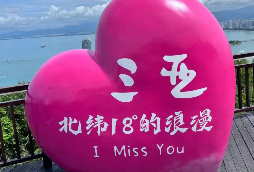 Luhuitou Peninsula Park,Sanya,Chinatour Large pink heart sculpture with white Chinese characters and the English phrase “I Miss You” overlooking a coastal boardwalk.