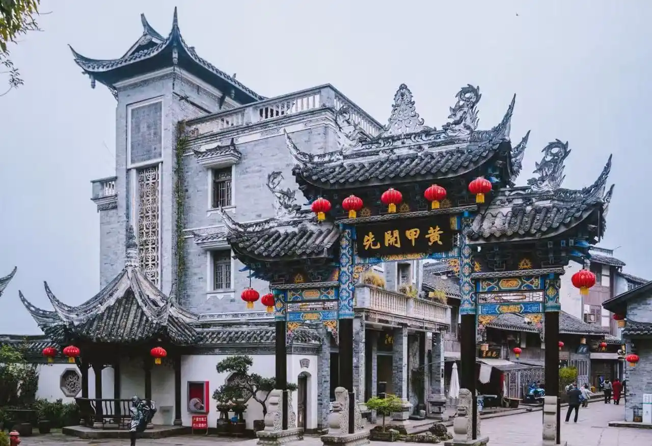 Tongliang Ancient Town,Chongqing,Chinatour Ornate Chinese paifang arch with blue-gold detailing and red lanterns in a temple courtyard