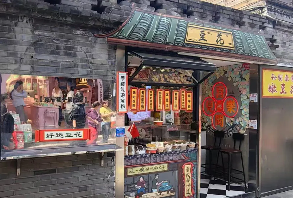 Kuanzhaixiangzi,Chengdu,Chinatour A small Chinese street-side shop selling snacks with hanging lanterns and storefront signs; people line up at the counter.