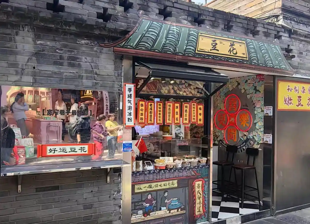 Kuanzhaixiangzi,Chengdu,Chinatour A small Chinese street-side shop selling snacks with hanging lanterns and storefront signs; people line up at the counter.