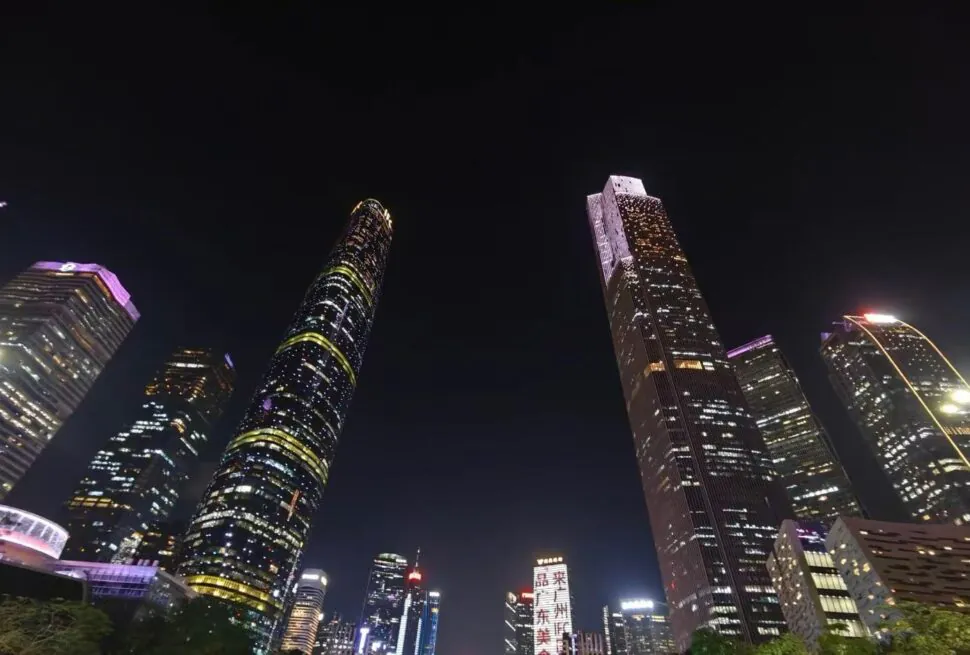 Zhujiang New Town CBD,Guangzhou,Chinatour Nighttime city skyline with tall, illuminated skyscrapers against a dark sky, colorful building lights creating a vibrant urban vista