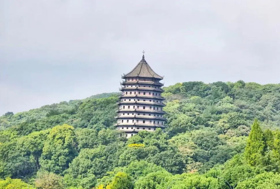 Six Harmonies Pagoda,Hangzhou,Chinatour Eight-tiered pagoda atop a forested hillside, surrounded by green trees.