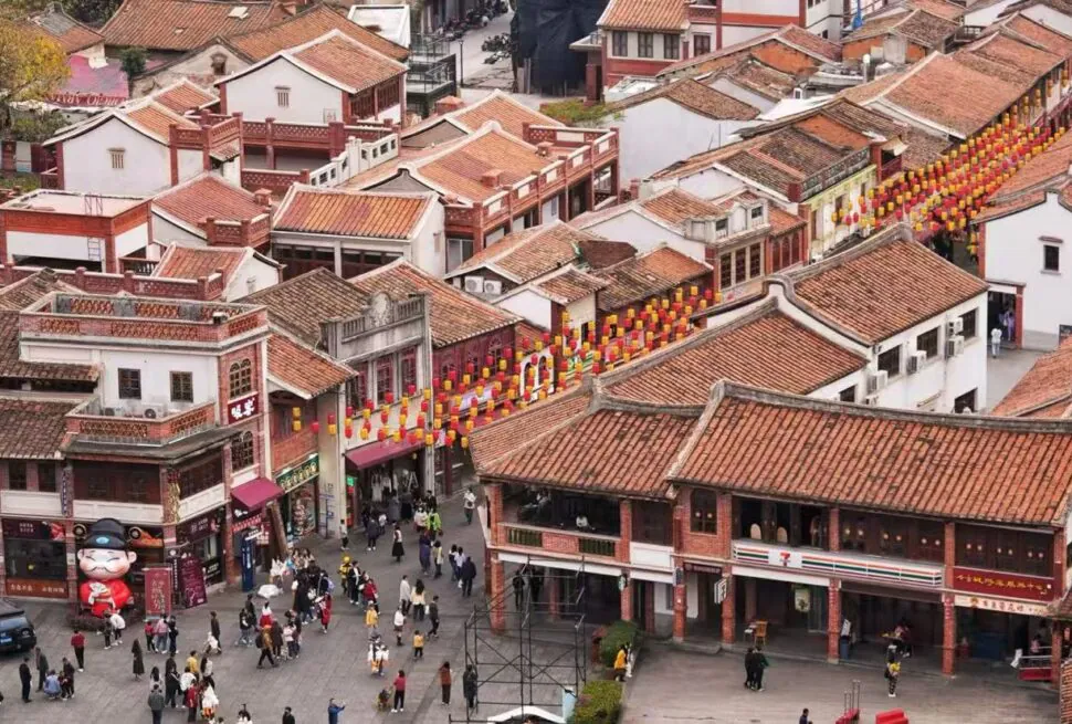 Zhangzhou Ancient City,Zhangzhou,Chinatour Aerial view of a crowded street in a traditional Chinese town with red-tiled roofs and rows of red and yellow lanterns