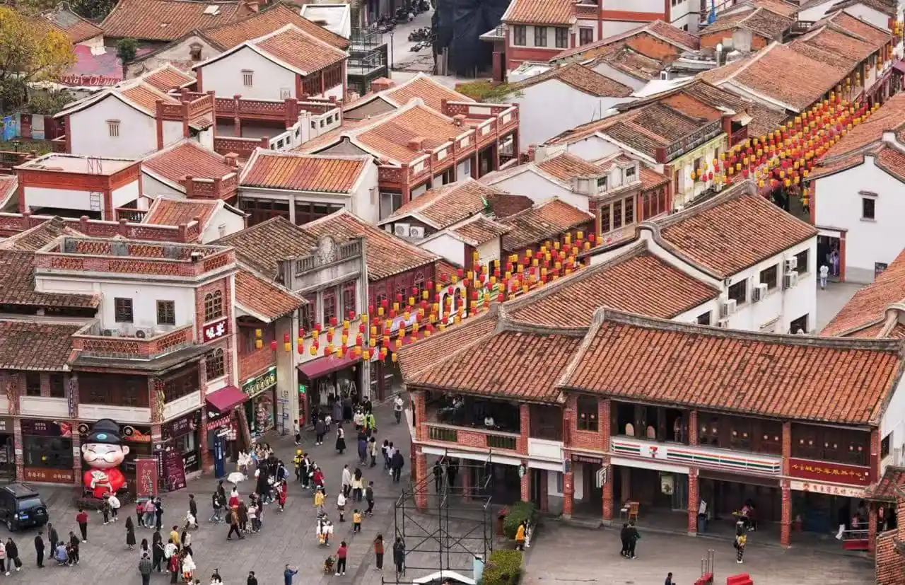 Zhangzhou Ancient City,Zhangzhou,Chinatour Aerial view of a crowded street in a traditional Chinese town with red-tiled roofs and rows of red and yellow lanterns