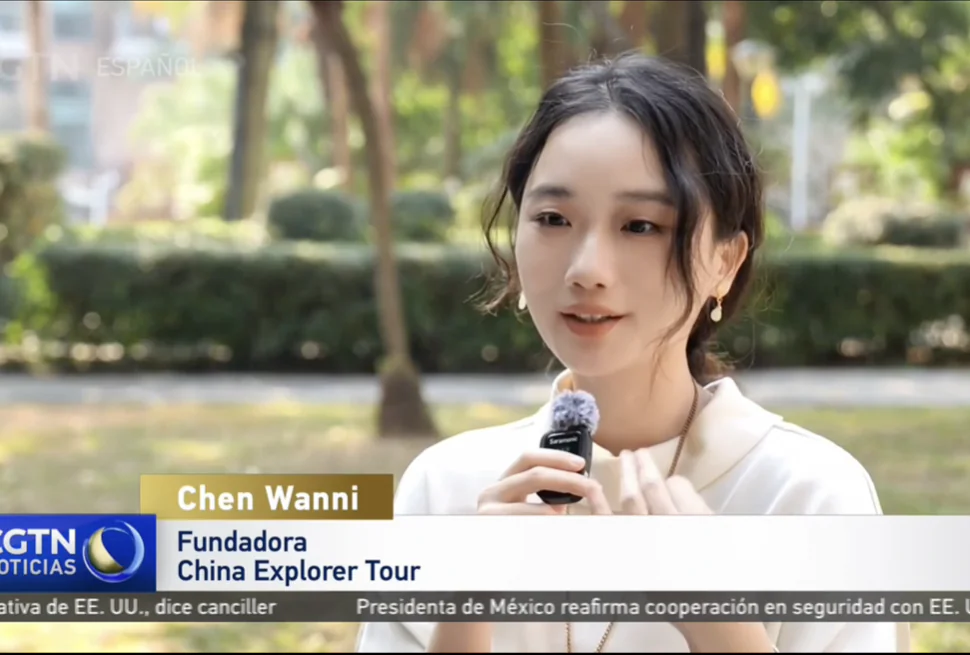 China explorer tour on CGTN Young woman speaks into a handheld microphone during an outdoor TV interview; CGTN Noticias banner at bottom.