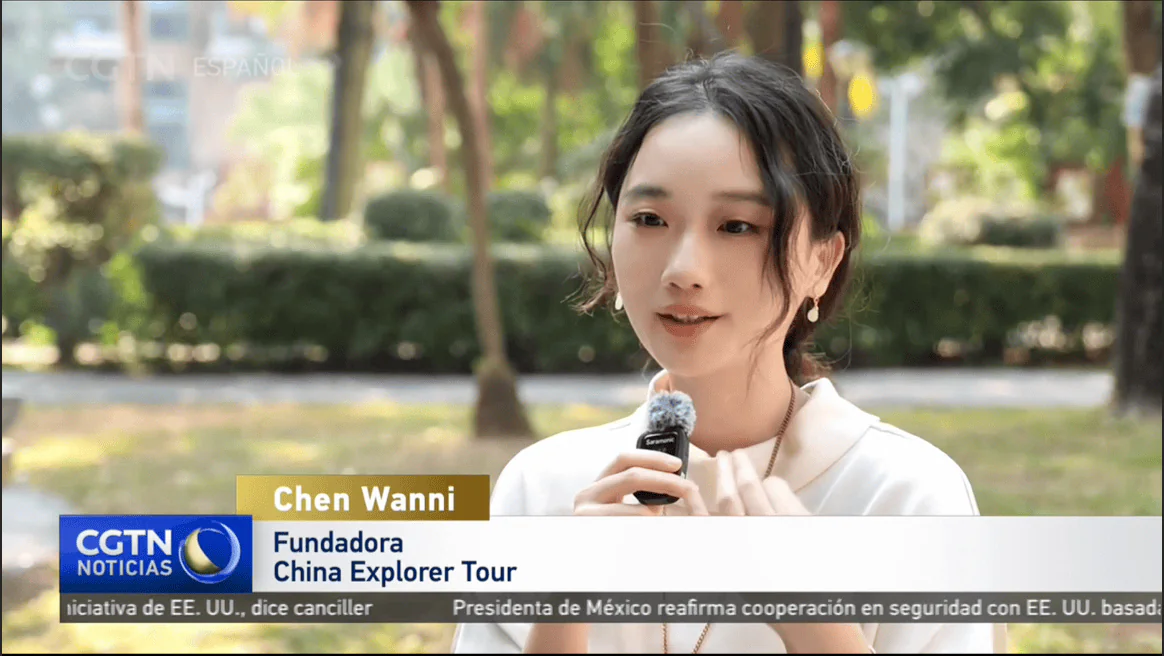 China explorer tour on CGTN Young woman speaks into a handheld microphone during an outdoor TV interview; CGTN Noticias banner at bottom.
