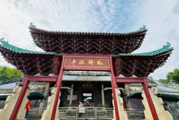 Ornate Chinese temple gate with sweeping green-tiled roofs and a gold plaque; visitors pass through the entrance.Fubo Hill Temple,Guilin,Guangxi ,Chinatravel