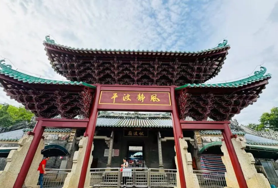 Ornate Chinese temple gate with sweeping green-tiled roofs and a gold plaque; visitors pass through the entrance.Fubo Hill Temple,Guilin,Guangxi ,Chinatravel